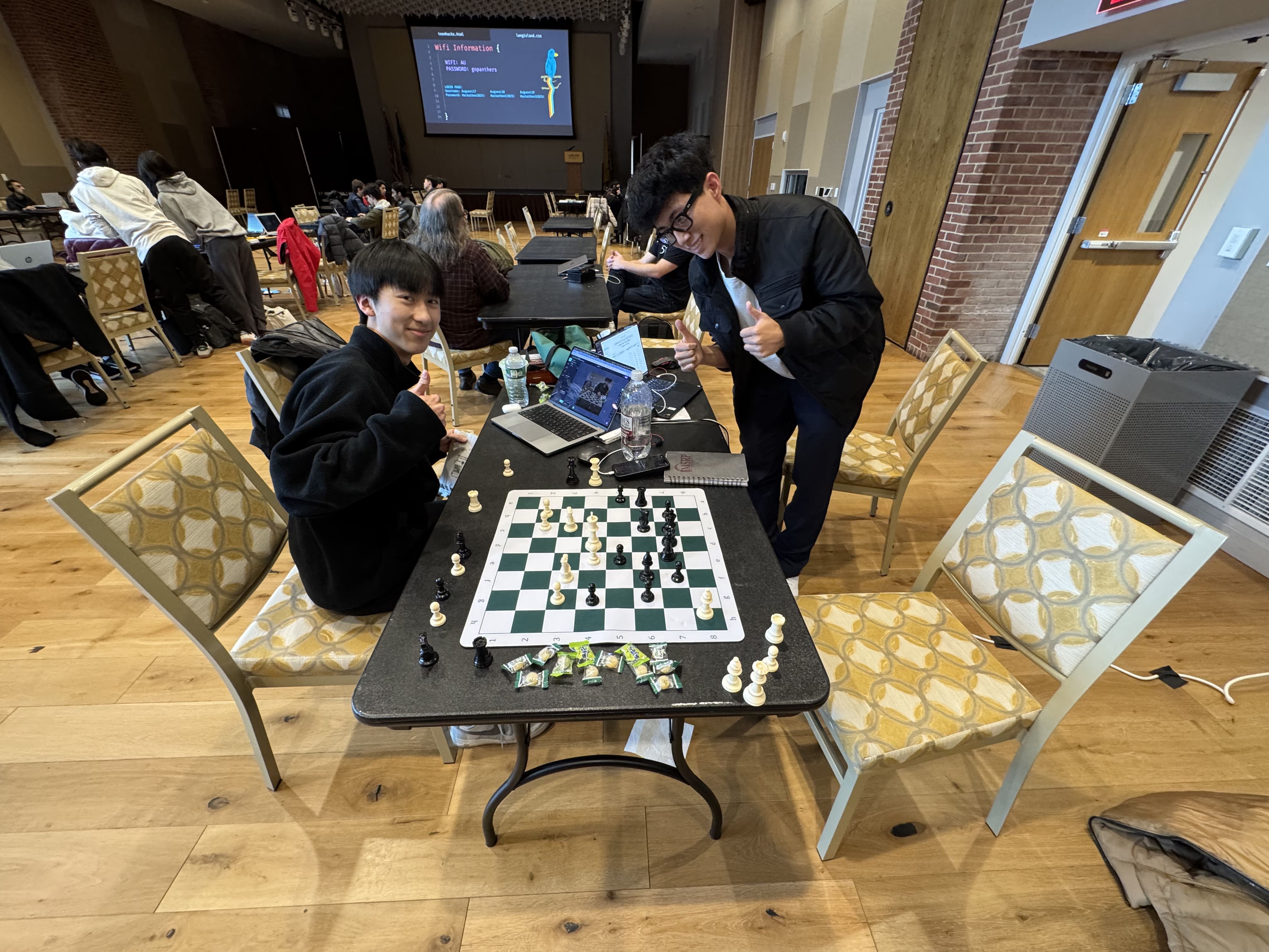 Caden and Eddy @ Teenhacks Hackathon working on AI chess glasses